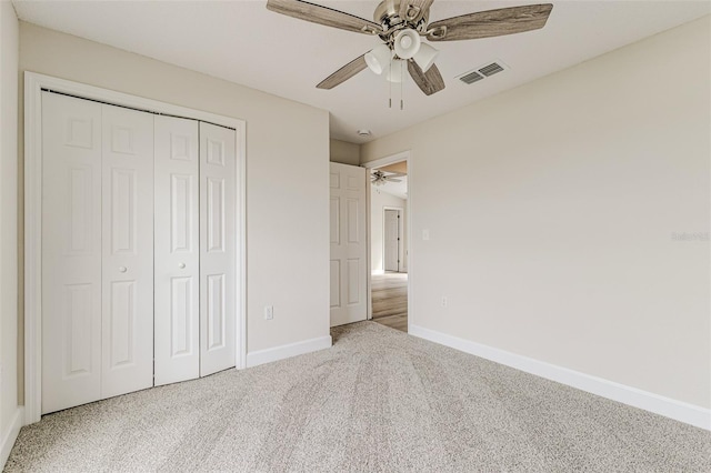 unfurnished bedroom featuring ceiling fan, visible vents, baseboards, a closet, and carpet