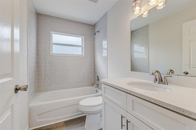 bathroom with toilet, vanity, wood finished floors, and shower / bathing tub combination