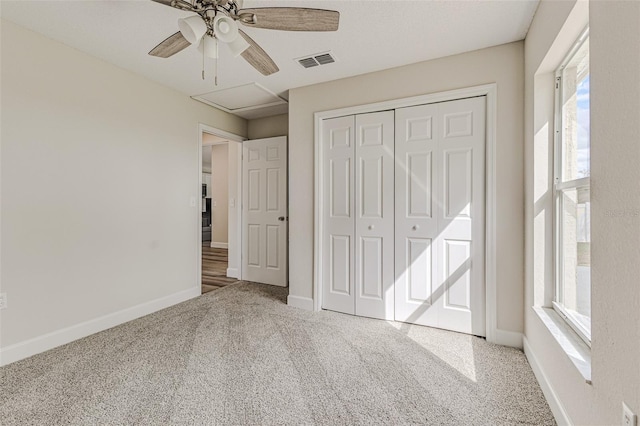 unfurnished bedroom with carpet flooring, a ceiling fan, visible vents, baseboards, and a closet