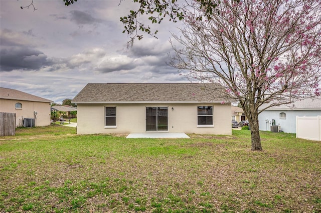 rear view of property featuring cooling unit, a patio, and a lawn