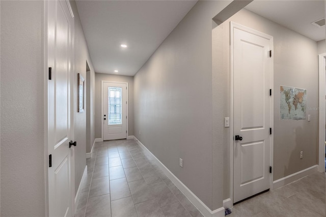 doorway to outside featuring light tile patterned floors, recessed lighting, and baseboards