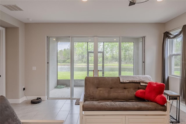 sitting room featuring light tile patterned floors, visible vents, and baseboards