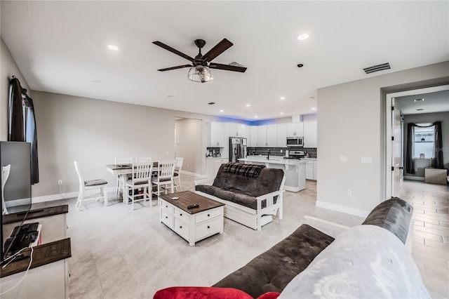 living area with recessed lighting, visible vents, baseboards, and ceiling fan