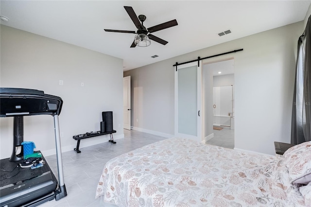 bedroom with a barn door, baseboards, visible vents, and ceiling fan