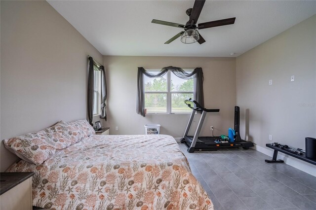 tiled bedroom with baseboards and ceiling fan