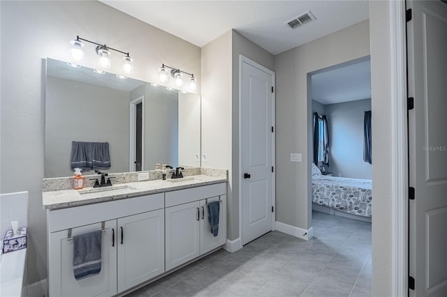 ensuite bathroom featuring double vanity, visible vents, ensuite bathroom, and a sink