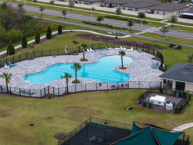 pool with a patio, a yard, and fence