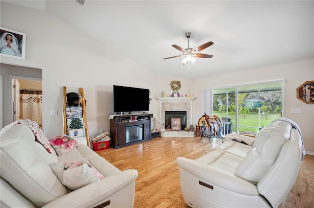 living area with high vaulted ceiling, a fireplace, wood finished floors, and a ceiling fan