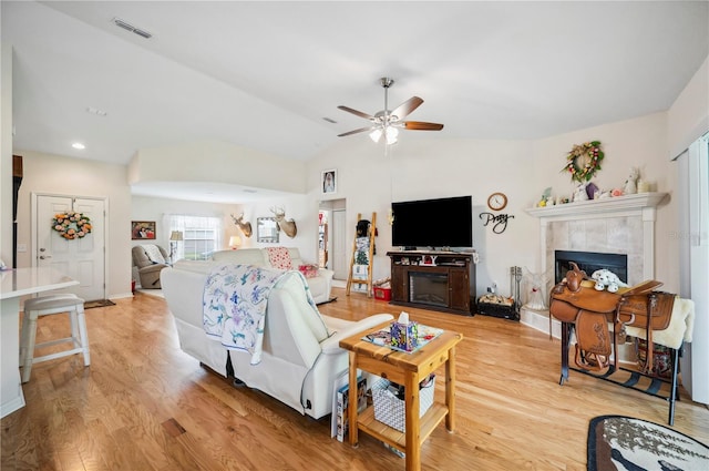 living area with a fireplace, wood finished floors, and visible vents