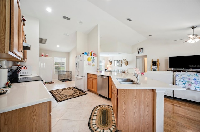 kitchen featuring white refrigerator with ice dispenser, a sink, open floor plan, light countertops, and stainless steel dishwasher