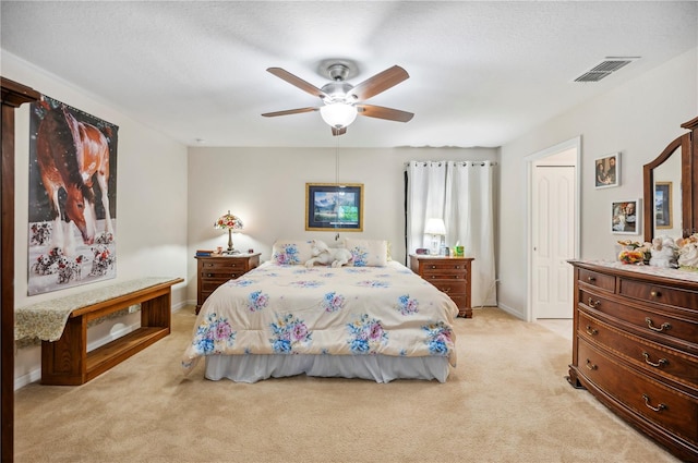 bedroom with a ceiling fan, light colored carpet, visible vents, and baseboards