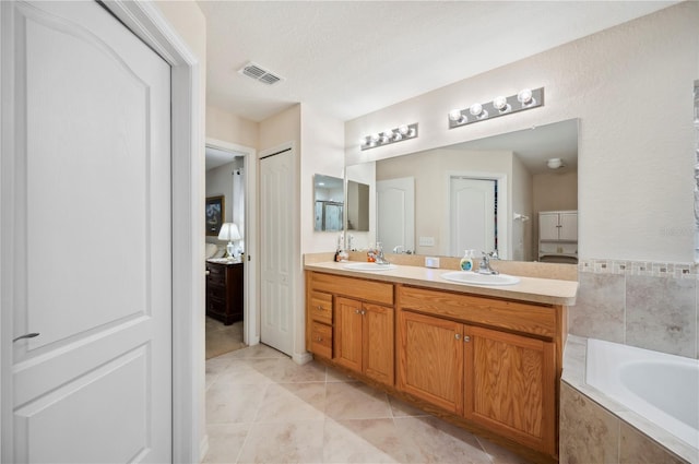 full bathroom featuring double vanity, a sink, visible vents, and a closet