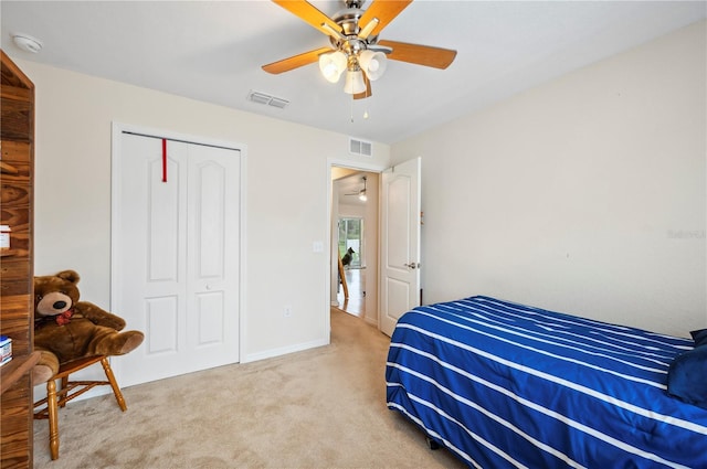 bedroom featuring a ceiling fan, a closet, visible vents, and light carpet