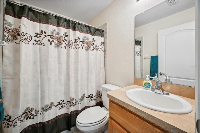 full bath with a textured ceiling, a textured wall, toilet, and vanity