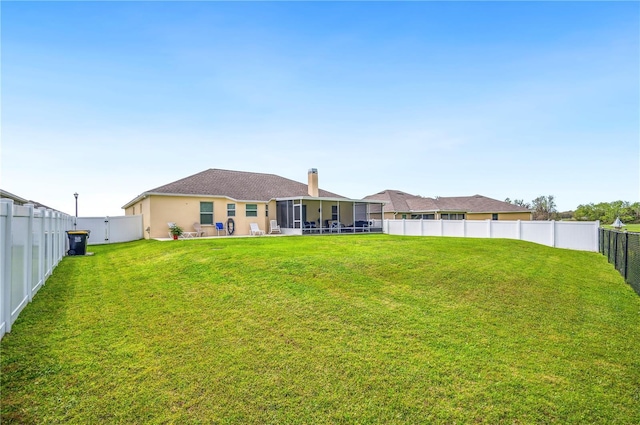 back of property featuring a sunroom, a fenced backyard, and a lawn