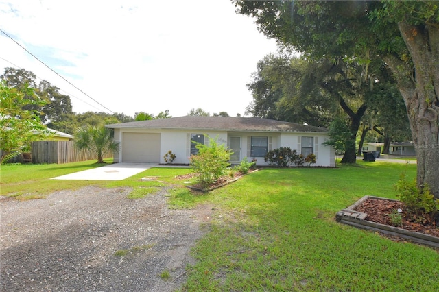 ranch-style house with an attached garage, fence, driveway, stucco siding, and a front yard