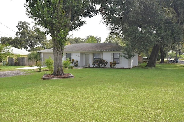 ranch-style home with an attached garage, driveway, a front lawn, and fence