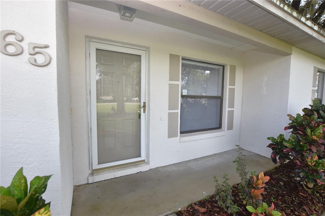 property entrance with stucco siding