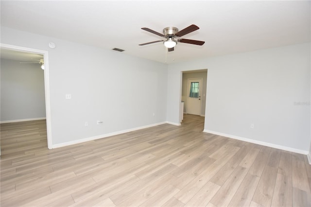 empty room with light wood-style flooring, visible vents, ceiling fan, and baseboards