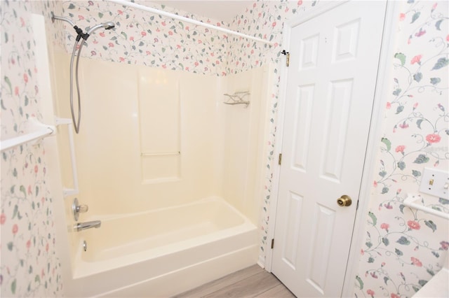 full bathroom featuring  shower combination, wood finished floors, and wallpapered walls