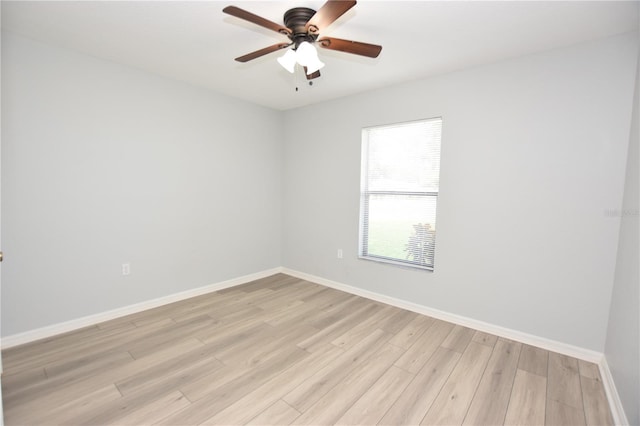 spare room featuring ceiling fan, light wood finished floors, and baseboards