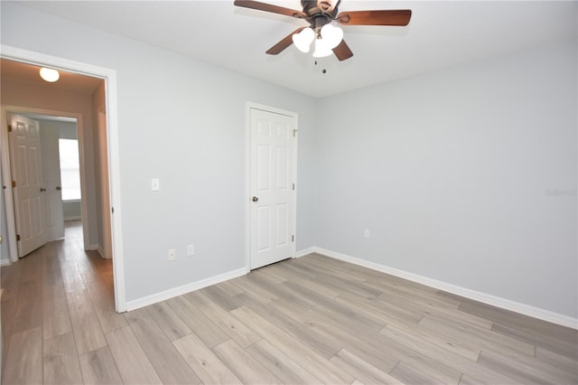 unfurnished room with light wood-style floors, baseboards, and a ceiling fan