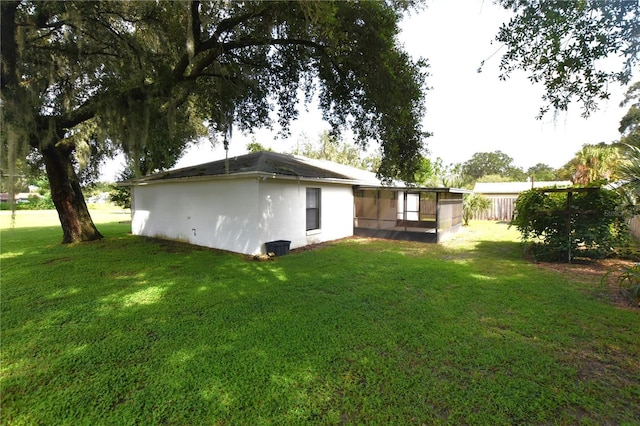 rear view of property featuring fence and a yard