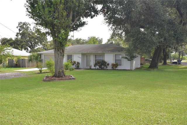 single story home with driveway, an attached garage, fence, and a front yard