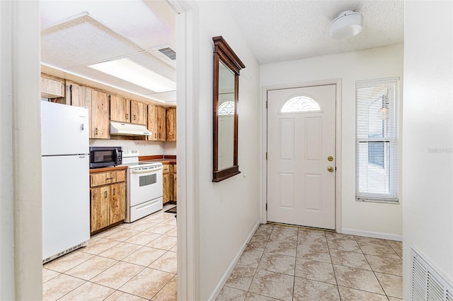 entrance foyer featuring light tile patterned floors, baseboards, a textured ceiling, and visible vents