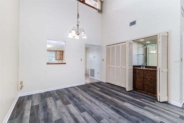 interior space with visible vents, a sink, wood finished floors, and a chandelier