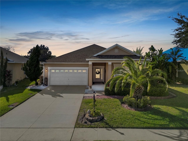 view of front of house featuring driveway, an attached garage, a front yard, and stucco siding