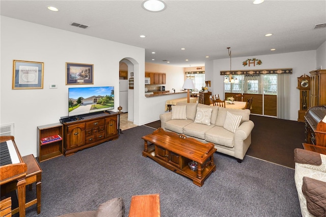 living area with arched walkways, recessed lighting, visible vents, carpet flooring, and a textured ceiling