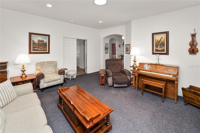 living area with arched walkways, dark colored carpet, a textured ceiling, and recessed lighting