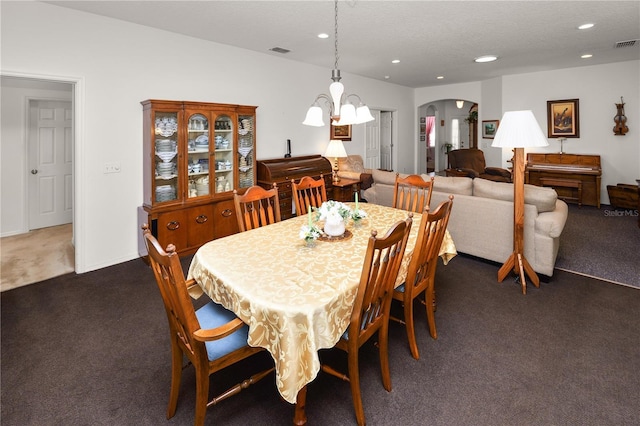 dining room with visible vents, arched walkways, a textured ceiling, dark carpet, and recessed lighting