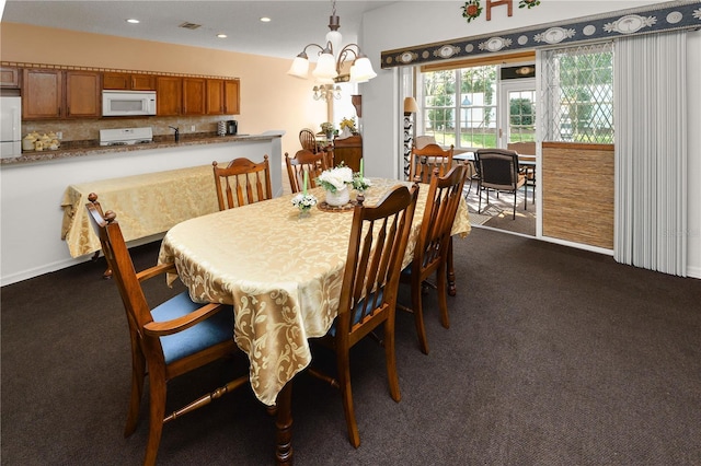 dining space featuring recessed lighting, visible vents, dark carpet, and an inviting chandelier