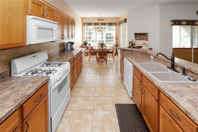 kitchen featuring light tile patterned floors, white appliances, a sink, backsplash, and decorative light fixtures