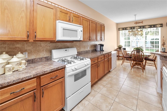 kitchen featuring light tile patterned floors, a chandelier, white appliances, hanging light fixtures, and decorative backsplash