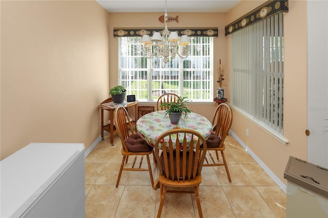 dining space featuring an inviting chandelier, baseboards, and light tile patterned floors