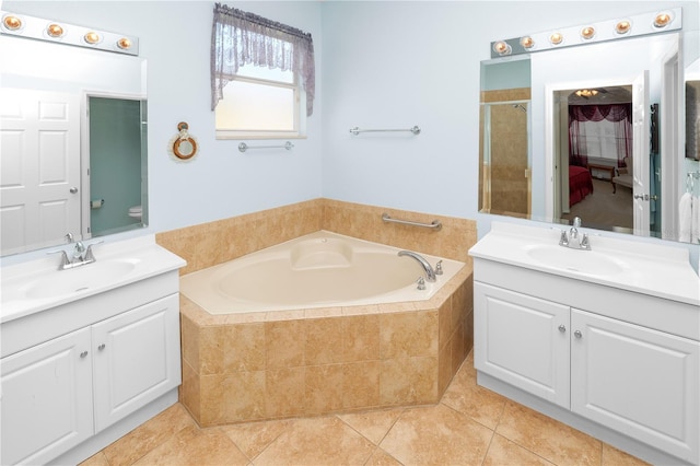 full bathroom featuring two vanities, a sink, and a bath