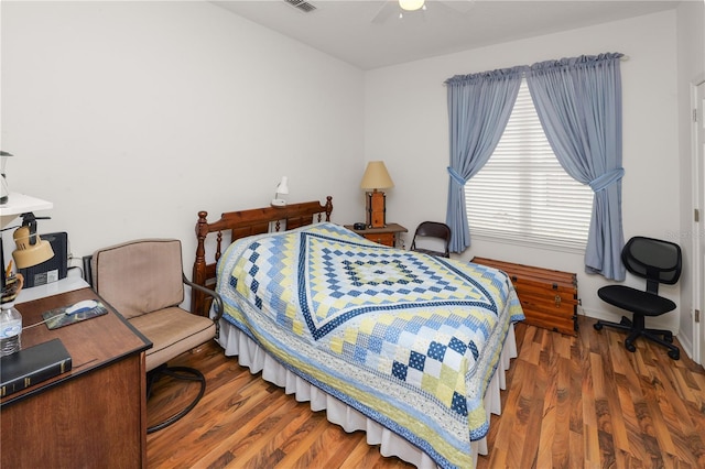 bedroom with dark wood-style floors, visible vents, baseboards, and a ceiling fan