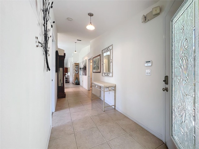 hallway featuring light tile patterned floors and baseboards