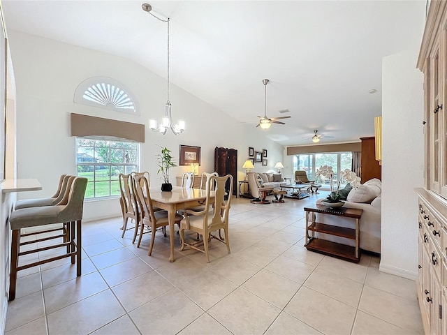 dining area with light tile patterned floors, high vaulted ceiling, and ceiling fan with notable chandelier