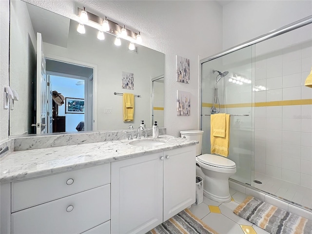 full bathroom featuring vanity, a shower stall, toilet, and tile patterned floors