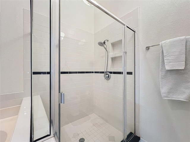 full bath featuring a stall shower and a textured wall