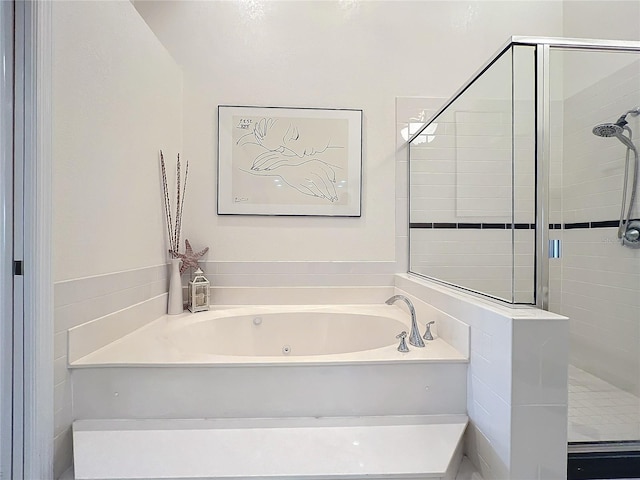 bathroom featuring a shower stall and a whirlpool tub