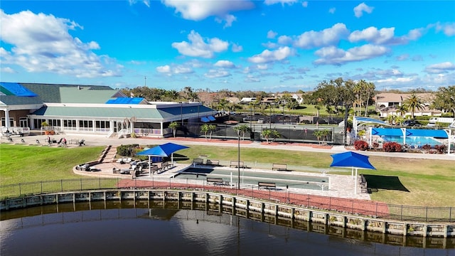 exterior space with a water view, fence, and a lawn