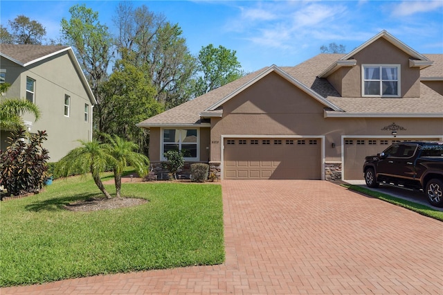 view of front facade with decorative driveway, stone siding, and stucco siding