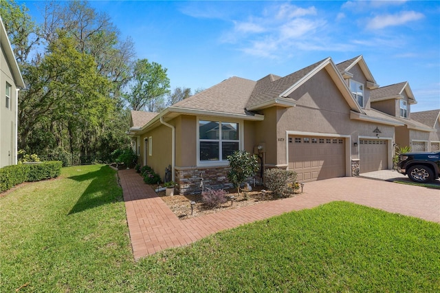 view of front of home with a garage, stone siding, decorative driveway, and stucco siding