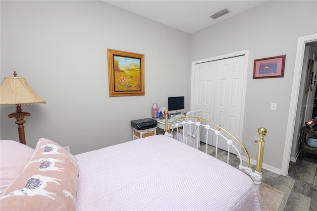 bedroom featuring a closet, light wood-type flooring, visible vents, and baseboards