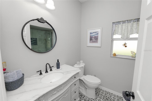 bathroom featuring tile patterned flooring, baseboards, vanity, and toilet